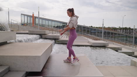 woman exercising outdoors by a fountain