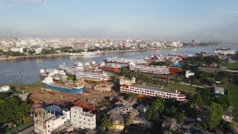 antena: astillero en la orilla del río buriganga con paisaje urbano en dhaka, bangladesh - toma de establecimiento de drones