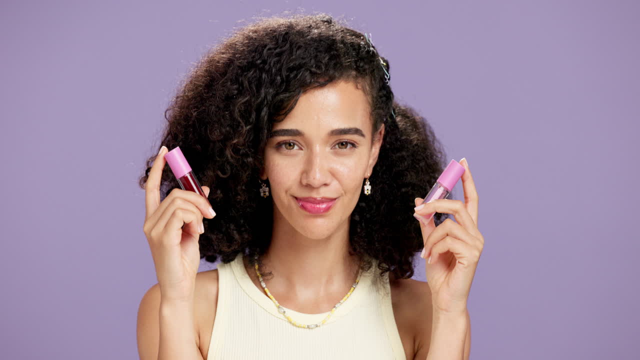 Woman Holding Lip Glosses on Purple Background