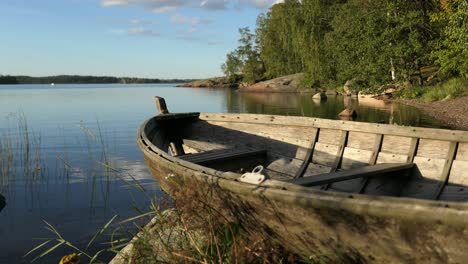 barco rústico de madera por aguas tranquilas bahía de mar, naturaleza idílica en finlandia, tiro de grúa