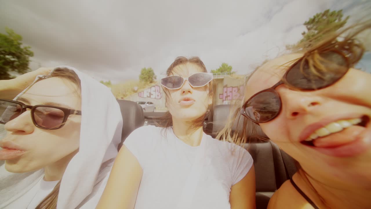 Three friends enjoying a road trip in a convertible