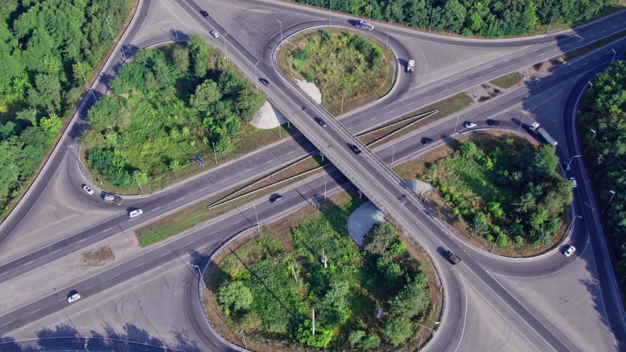 Road intersection with roundabouts and vehicles on a sunny day