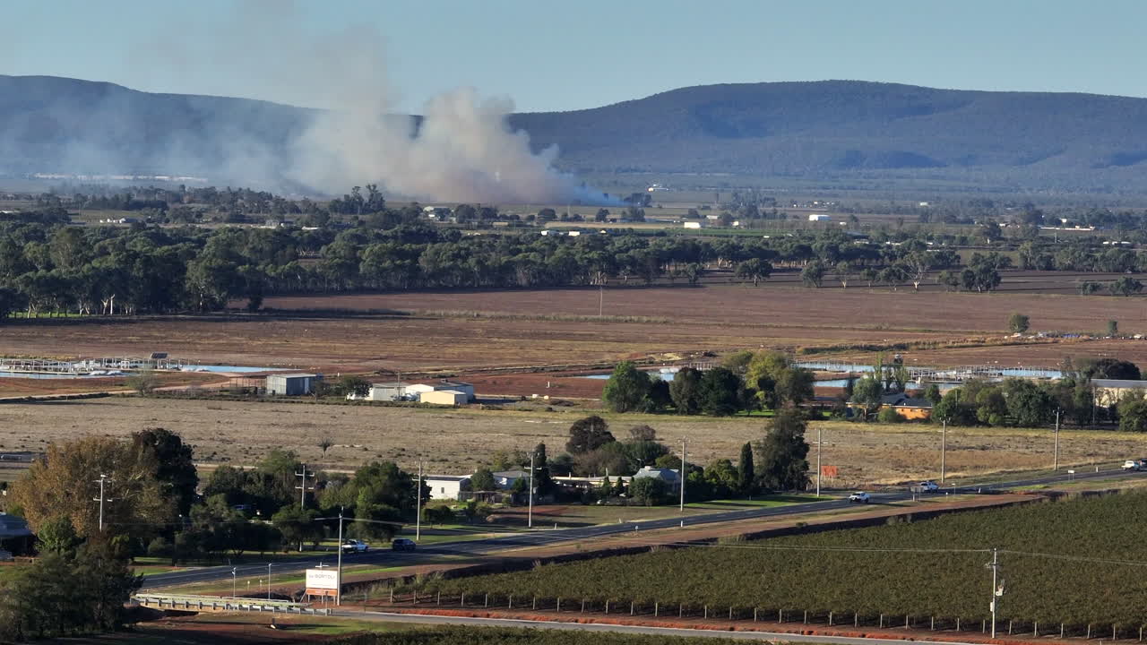 Aerial: Drone shot of large white clouds of smoke coming from a agriculture fire burning in Griffith, NSW Australia