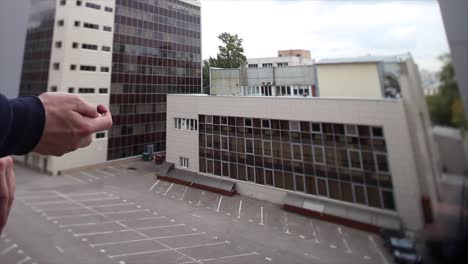 person holding smartphone in front of city buildings