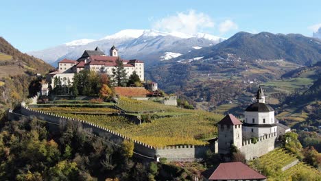 aerial drone over a medieval castle in the middle of the vineyards in italy named salita sabiona