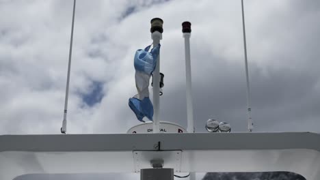 bandera azul y blanca de argentina moviéndose en el viento en el mástil de un velero