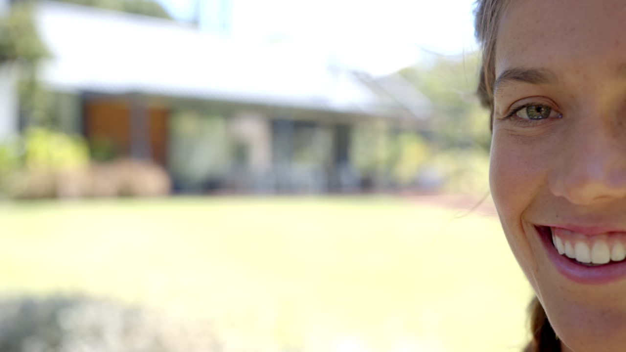 Enjoying sunny day, smiling woman outdoors with blurred background, copy space