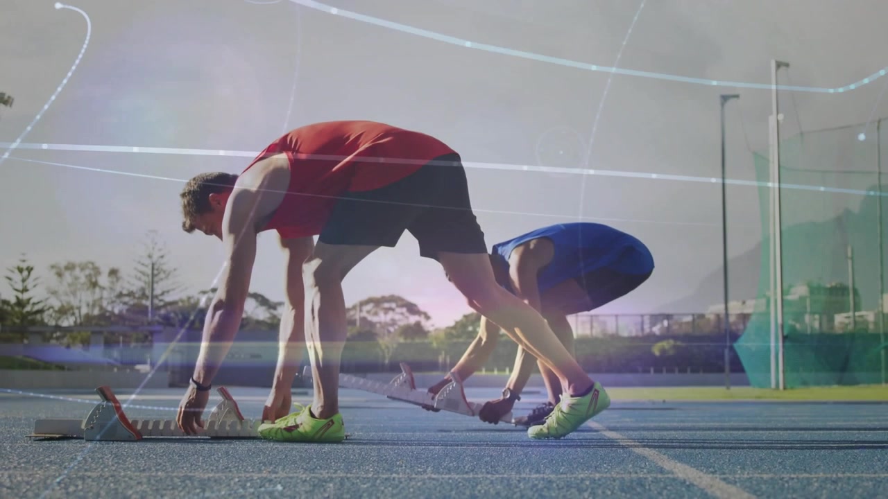 Due velocisti inginocchiati che infilano i piedi nei blocchi di partenza su una pista blu, in attesa del segnale di partenza dell'atletica