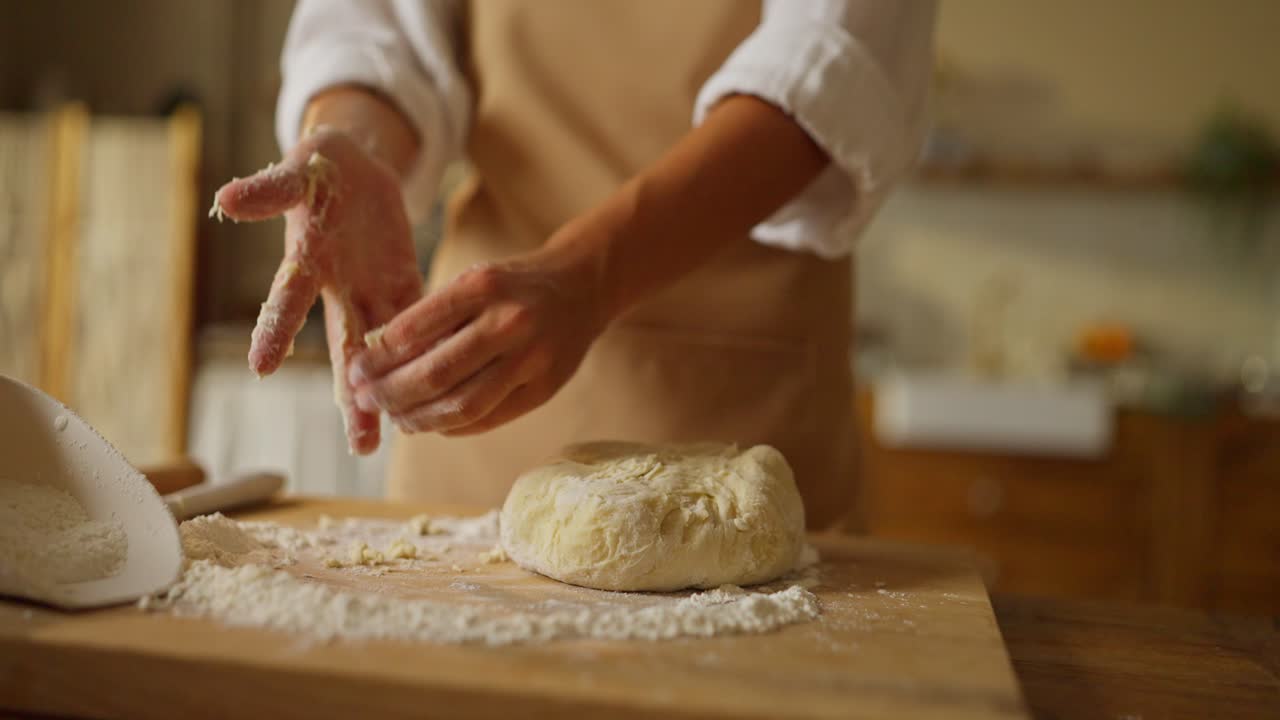 A woman is making dough in the kitchen