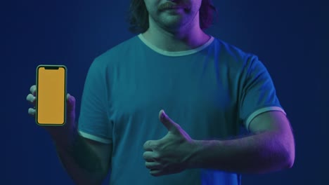 man holding a smartphone with a thumbs up
