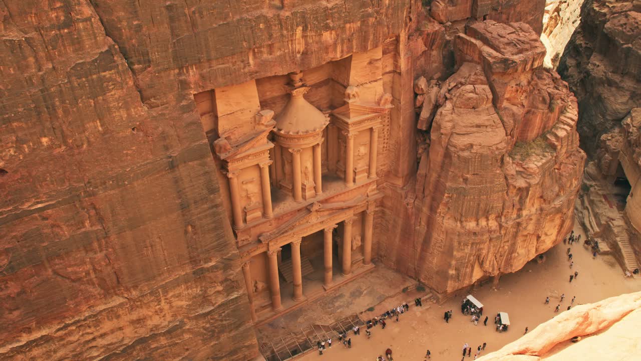 Vue de dessus du Trésor d’Al-Khazneh à Pétra, en Jordanie, montrant des touristes au pied de la façade en grès sculpté dans l’ancienne cité nabatéenne