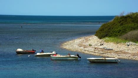 barcos de pesca estacionados en la tranquila bahía del mar, pescador preparando las redes y el anzuelo