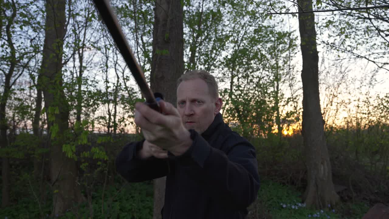 Hunter aiming his gun towards camera - wide shot