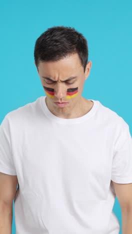 Dignified and serious man with german flag painted on face