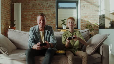 father and son enjoying video games together at home