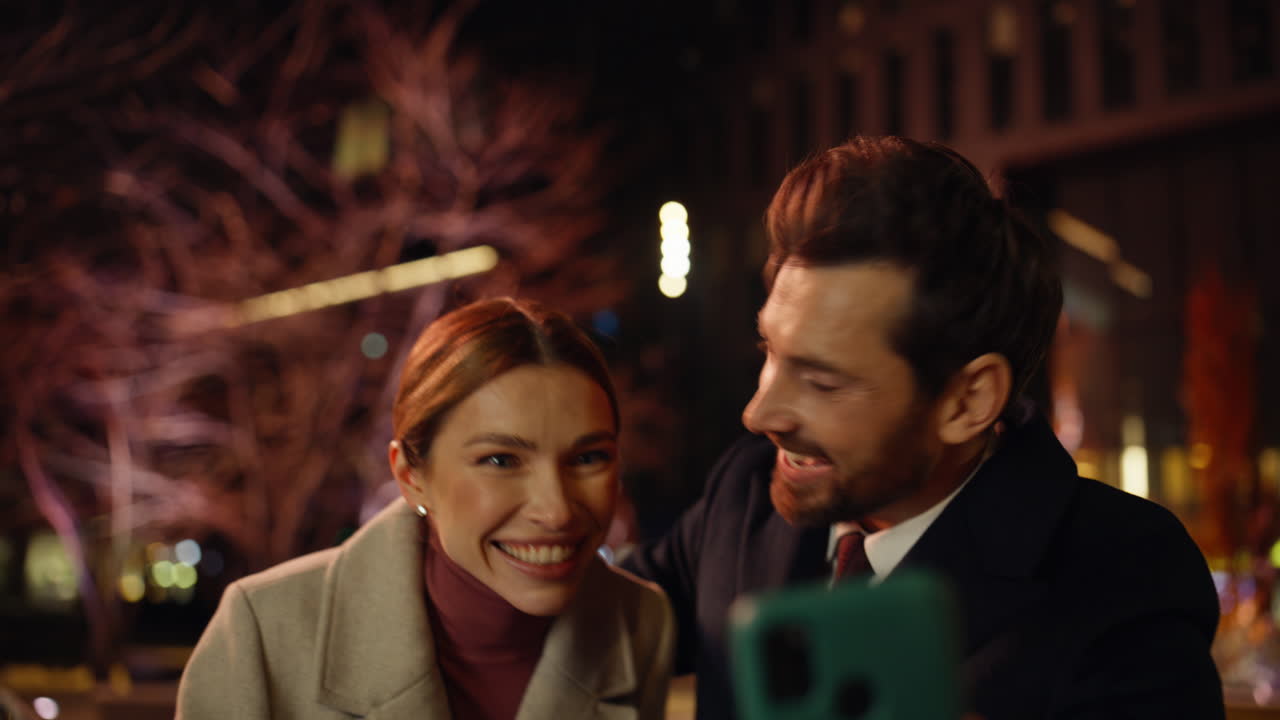 Emotional spouses videocalling night town closeup. Couple waving hands greeting