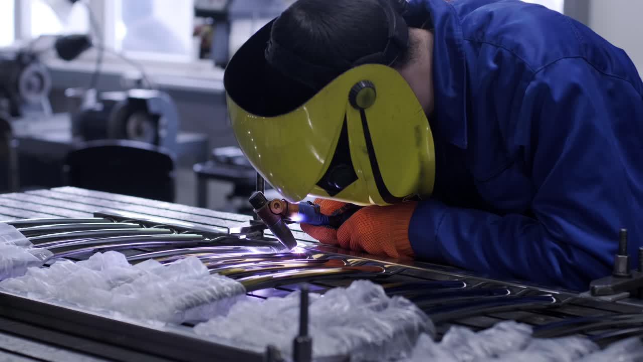 Man wearing mask welding in a workshop. Metal workers use manual labor. Skilled welder. Welder is welding the stainless steel pipes in the factory. welder Industrial part in factory.