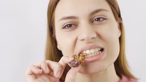 Close-up-woman-eats-fresh-dried-dates.