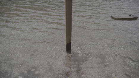 rising up to a wooden keep out sign on a lake in slow motion