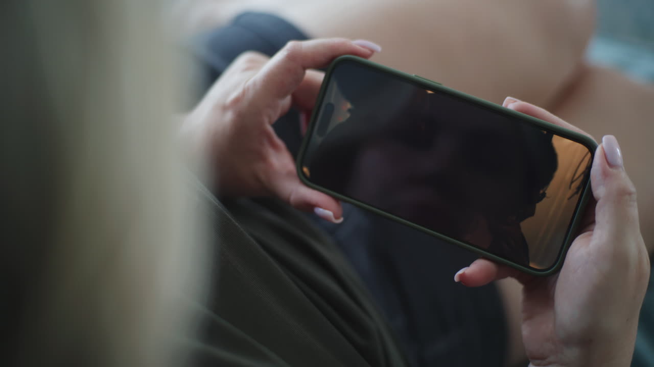 스마트폰에서 비디오를 보는 여자