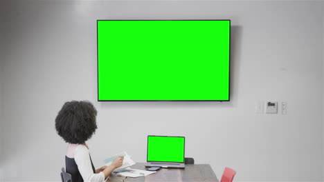 mujer de negocios afroamericana en video llamada con pantalla verde de tv
