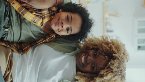 portrait of joyous african american mom and little son hugging on couch at home