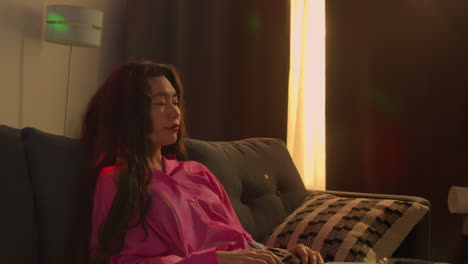 집 파티에서 알코올을 마신 후 소파에서 깨어난 여성은 숙취로 고통 받고 휴대 전화 메시지를 확인합니다.