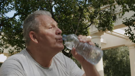 elderly man drinks water bottles