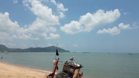 Tropical-beach-with-wooden-fishing-boat-on-sand