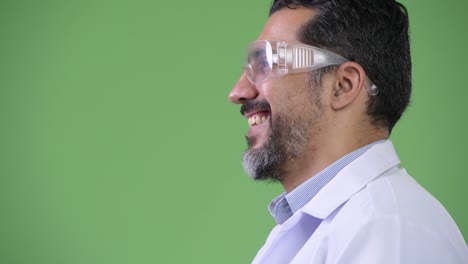 profile view of handsome persian bearded man doctor wearing protective glasses