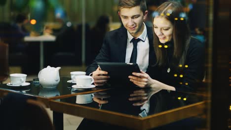 A-couple-in-love-rests-in-a-cafe-and-uses-a-tablet-2