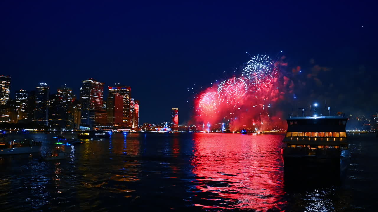 Amazing fireworks in the sky over the waterscape. Multiple boats are on the river. Skyline of New York, USA at night