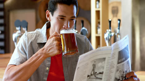 Mann-Trinkt-Bier,-Während-Er-In-Einem-Restaurant-Zeitung-Liest-4k