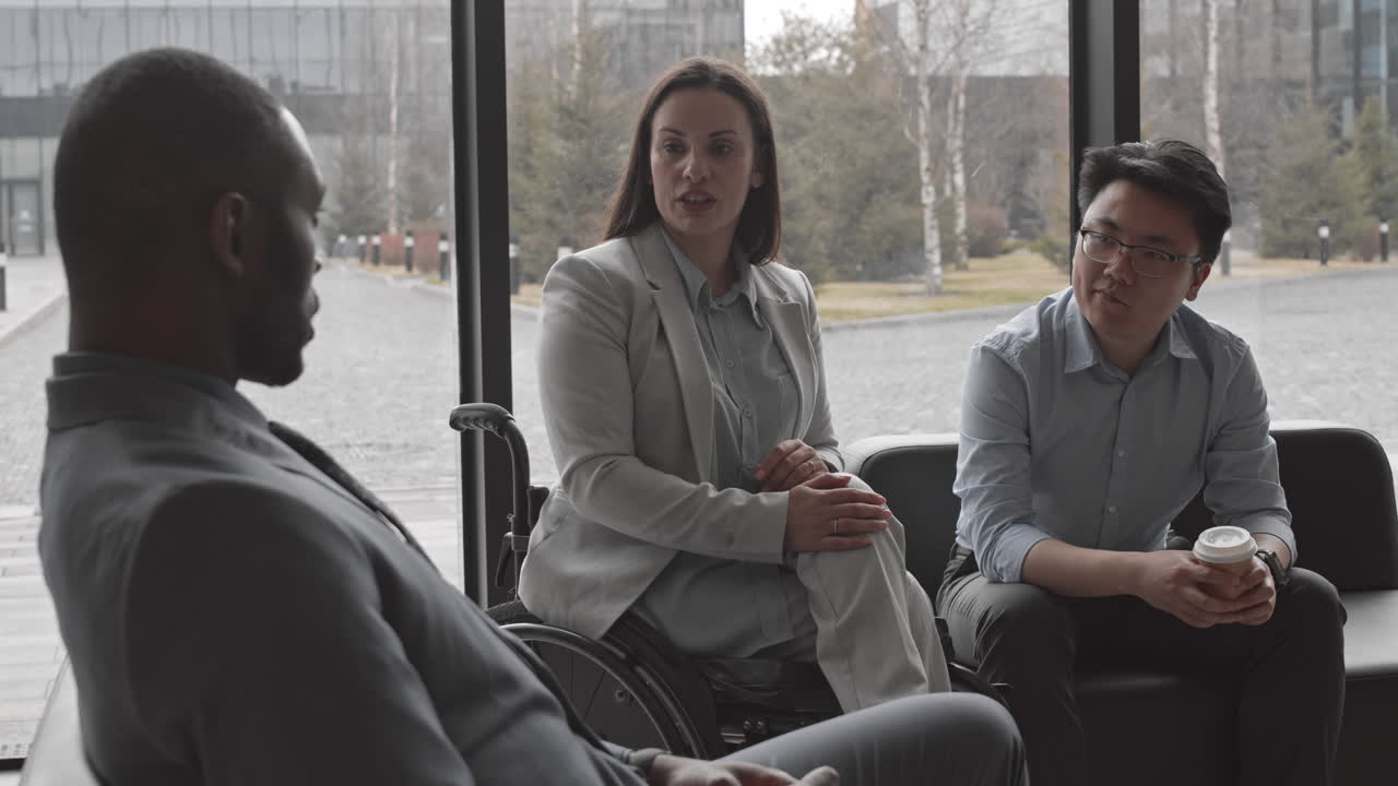 Businesswoman with Disability Having Talk with Two Colleagues