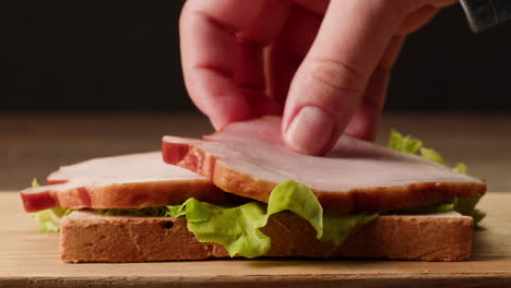 making a ham and lettuce sandwich