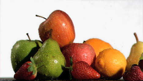 water sprayed on fresh fruits in super slow motion