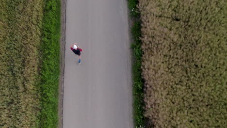 aerial of running man with gps running watch in rural area