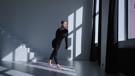 mujer haciendo estiramientos de yoga en un estudio