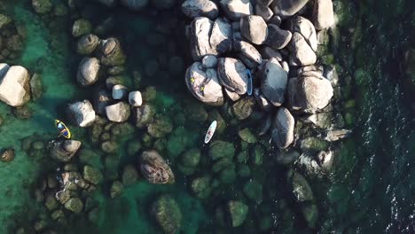 Ascending-Top-Down-Aerial-View-on-Kayak-In-Water-Between-Rocks