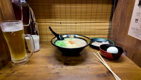 Zoom-out-shot-of-a-bowl-of-ramen-at-Ichiran-in-Japan,-featuring-rich-broth,-noodles,-and-garnishes