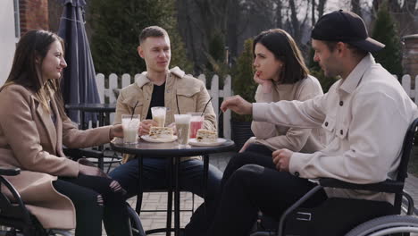 grupo de amigos tomando batidos y pasteles en la terraza de un bar