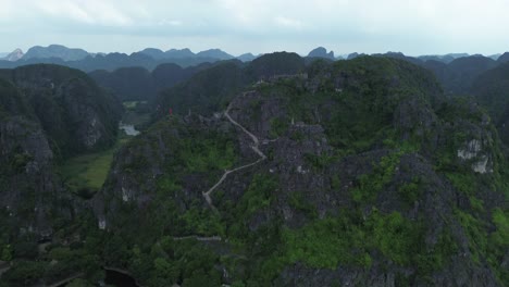 camera lifting from lotus ponds and trees up to rocky limestone cliffs in lush ninh binh region