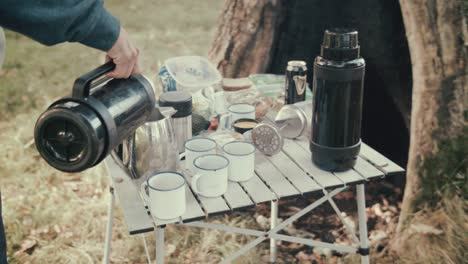 man pouring hot water into tea pot camping on island