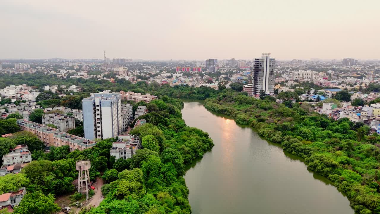 Vista aerea di un paesaggio urbano con un fiume che serpeggia tra alberi verdi e rigogliosi. Infrastrutture moderne