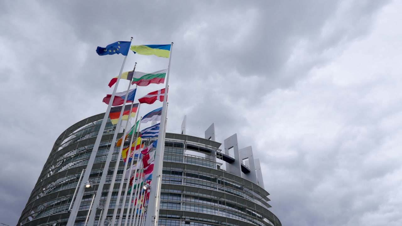Guardando in alto le bandiere degli stati membri dell'UE che sventolano davanti all'edificio del Parlamento Europeo a Strasburgo, Francia