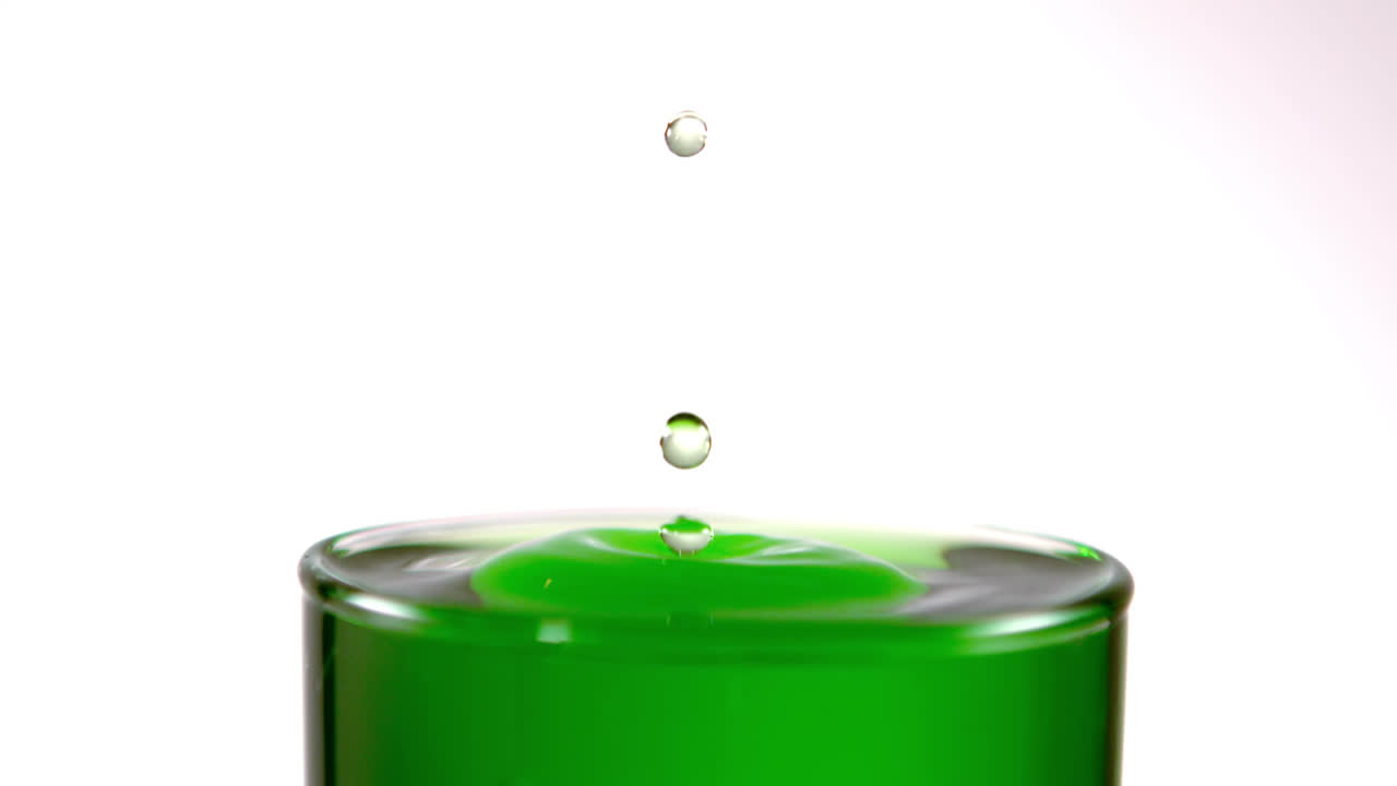 유리잔 속에 느린 움직임으로 떨어지는 방울