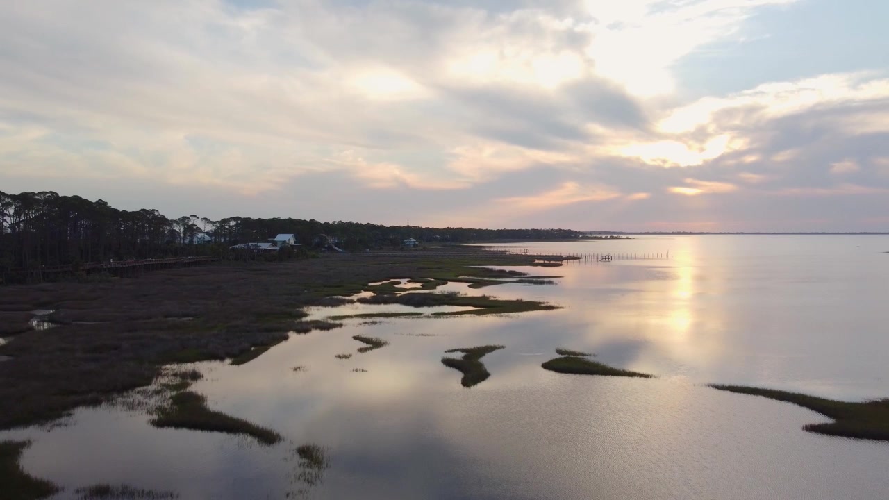 Ripresa aerea con drone in 4K della costa della Florida al tramonto, con vista su una palude in un porto su una penisola a Port Saint Joe, Florida, in primavera. Un luogo utilizzato per la pesca, la nautica e l'esplorazione della natura