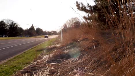 Car-driving-into-the-sunset-along-an-empty-asphalt-road-in-Bloomington-Minnesota