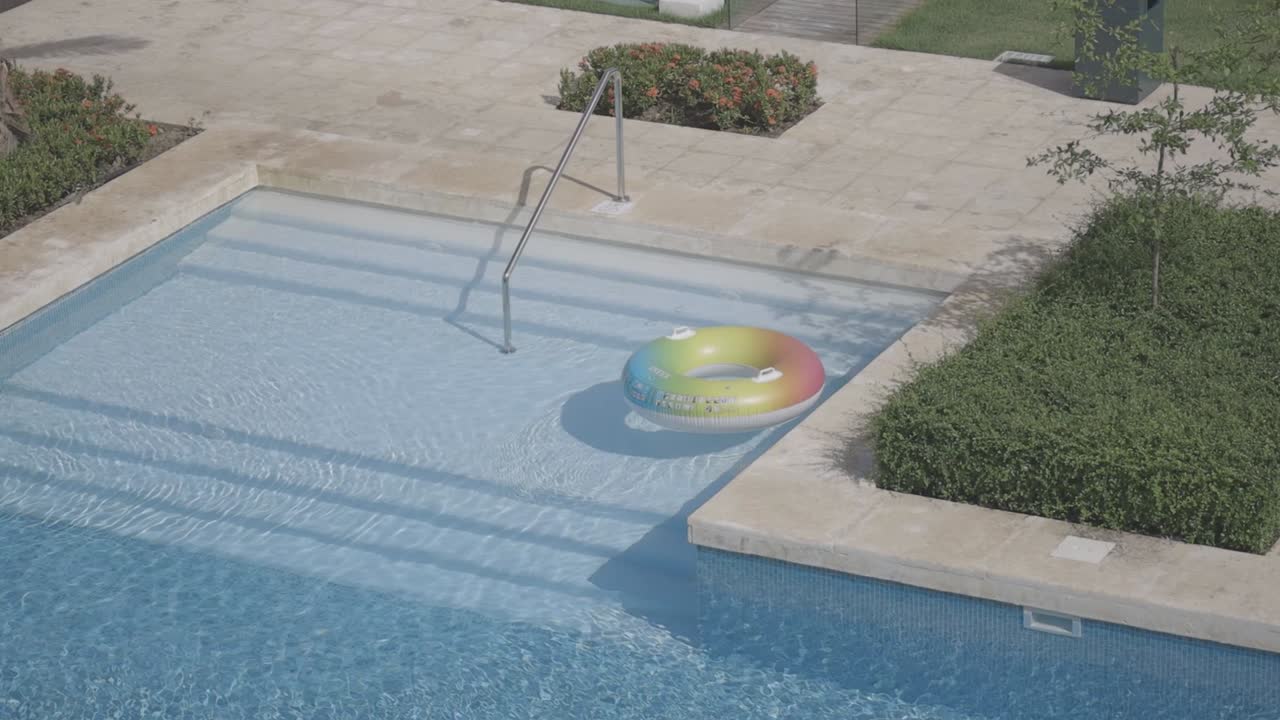 swimming pool that is the main focus of the scene. The pool is filled with crystal clear water that sparkles under the sunlight.