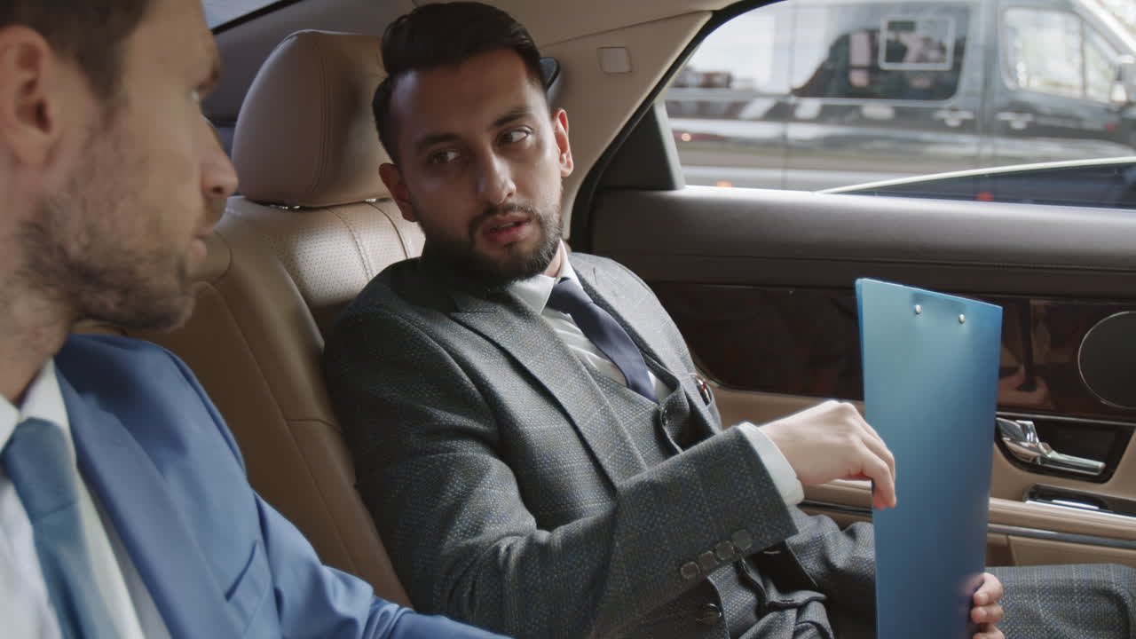 Mixed-Race Businessman Talking to Partner in Car